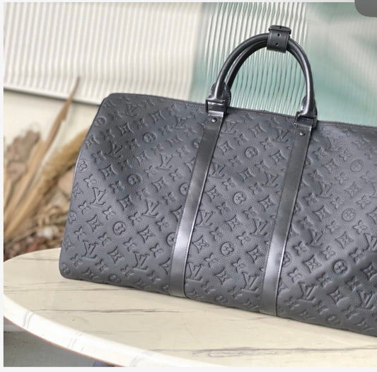 Gray embossed handbag with brand logo on a white surface